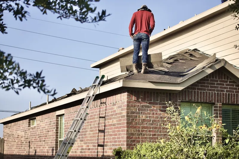 Professional roofer working on a residential roof in The Landing